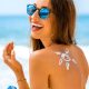 mulher sorrindo na praia com protetor solar