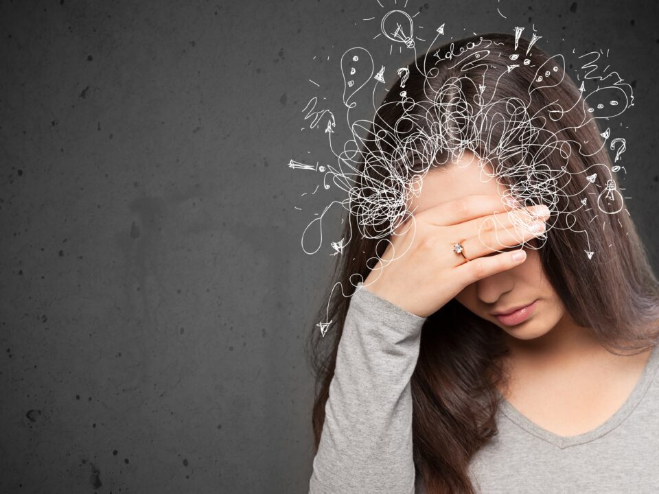 Moça com a mão no rosto, olhando para baixo (como se estivesse confusa), e alguns rabiscos na cabeça dela, simbolizando pensamentos confusos e falta de foco