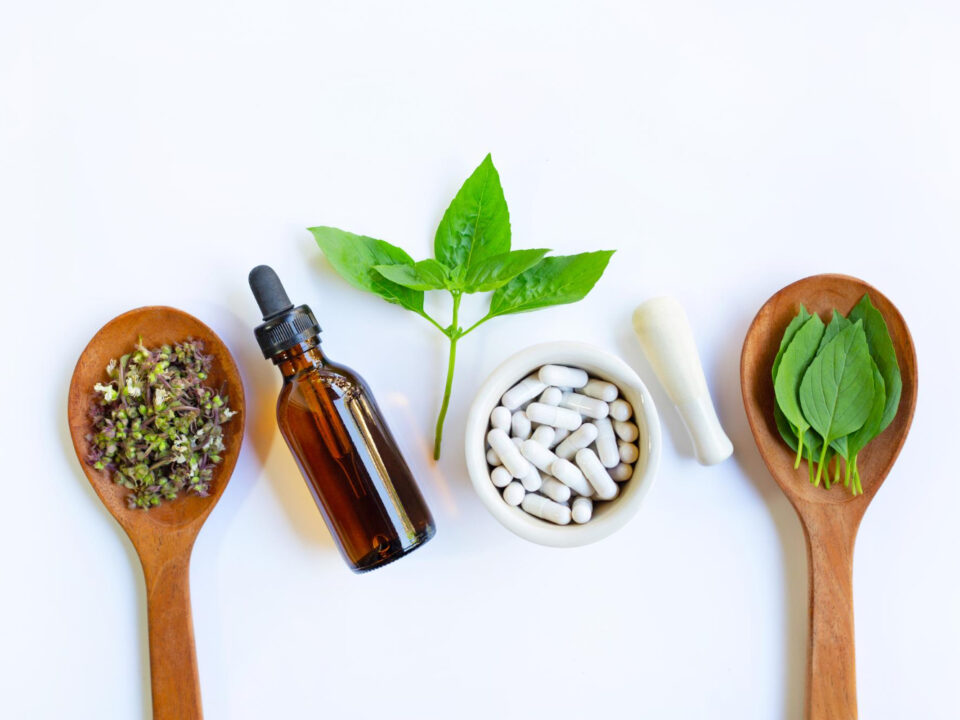 Mesa com vista por cima, apresentando suplementos, manipulados e ervas naturais na mesa