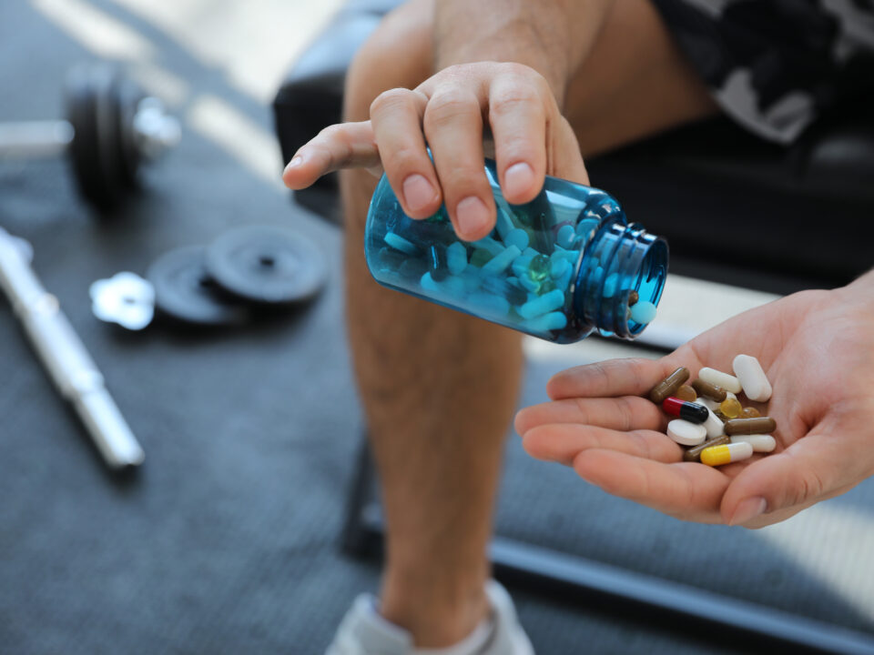 homem segurando pote de manipulado em mãos